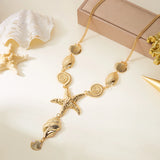 Collier doré avec pendentifs coquillages variés et une grande étoile de mer centrale, posé sur un fond clair avec des éléments de décoration marins