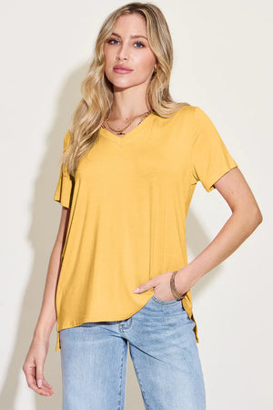Femme portant un T-Shirt V-Neck jaune en bambou et élasthanne, style décontracté avec jeans.