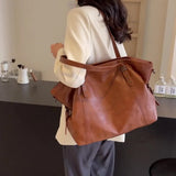 Femme portant un sac cabas femme marron en cuir PU souple sur l'épaule, vue de dos