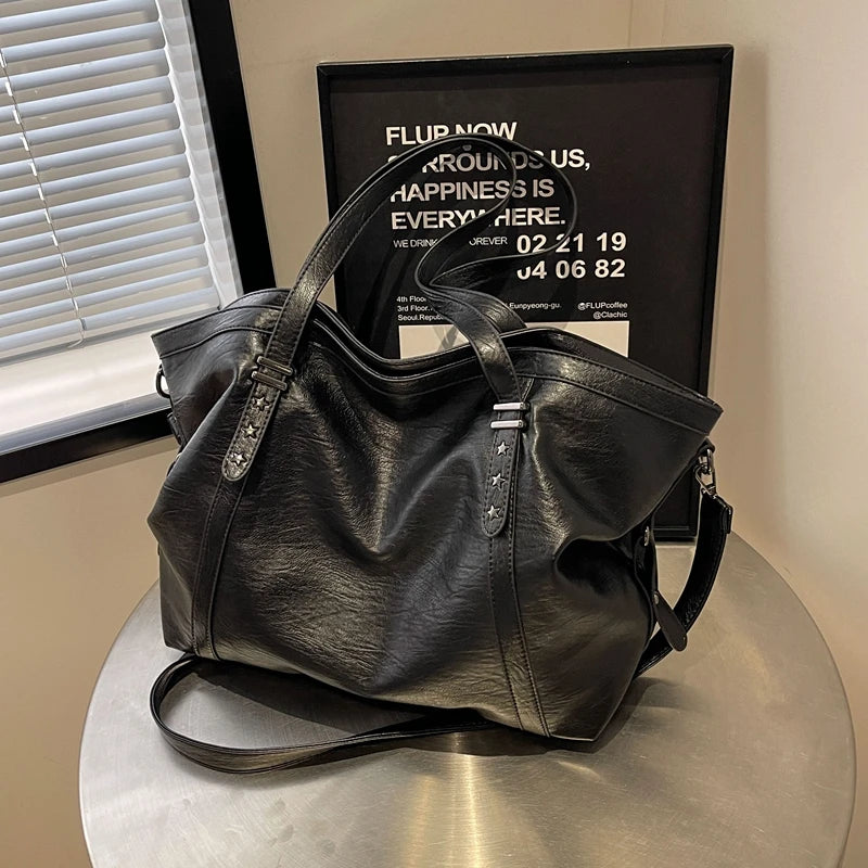 Sac cabas femme noir grand format en cuir PU souple posé sur une table