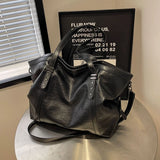 Sac cabas femme noir grand format en cuir PU souple posé sur une table