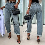 Jean ample pour femme en denim, style streetwear hipster, taillé avec taille haute et pantalon retroussé.