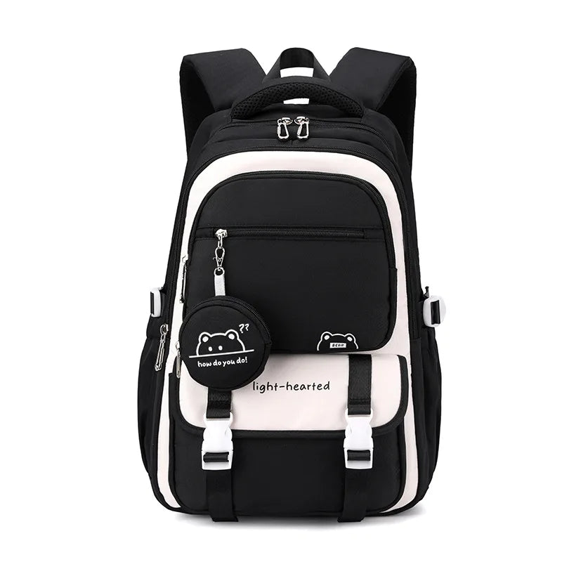 Sac à dos scolaire noir et blanc avec motif cartoon et inscription "light-hearted".