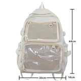 Sac à dos Ita transparent rose sur fond blanc, mis en scène avec des accessoires kawaii et des pin's
