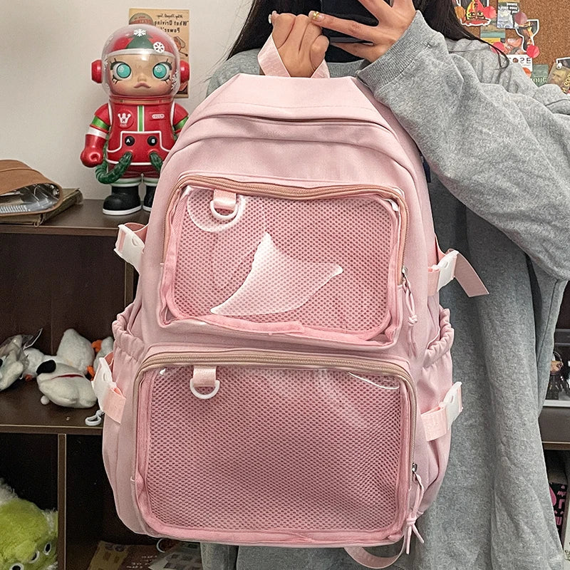 Sac à dos Ita transparent rose porté par une femme, mettant en avant son design kawaii et ses poches d'affichage