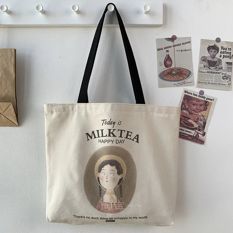 Sac fourre-tout en toile couleur crème avec illustration 'Milk Tea Happy Day' et anses noires, style décontracté