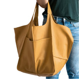 Sac à main hobo jaune moutarde grande capacité porté à l'épaule par une femme