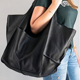 Sac à main hobo noir grande capacité porté à l'épaule par une femme, vue rapprochée