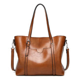 Sac à main femme en similicuir couleur noir, porté à l'épaule, détails du fermoir