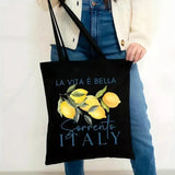 Sac cabas noir motif La Vita è Bella Sorrento Italy et citrons, porté par une femme