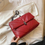 Sac à main matelassé rouge avec chaîne sur fond blanc, touche de couleur vive