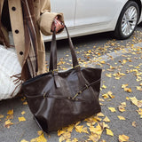 Femme avec sac fourre-tout rétro marron dans un décor automnal