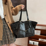 Femme tenant un sac fourre-tout rétro noir