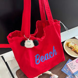 Détail du sac de plage rouge 'Beach' avec un porte-clés