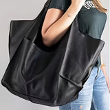 Femme portant un sac cabas noir grande capacité à l'épaule