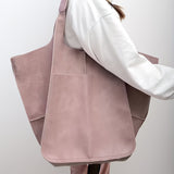 Femme portant un sac cabas rose pâle grande capacité à l'épaule