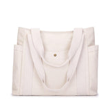 Sac cabas en toile beige clair, vue frontale, avec anses claires et bouton pression doré