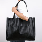 Sac cabas femme noir aspect cuir porté épaule avec pantalon jean