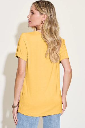 Femme portant un T-Shirt V-Neck haut-bas en bambou, de dos, en couleur jaune, associé à un jean.